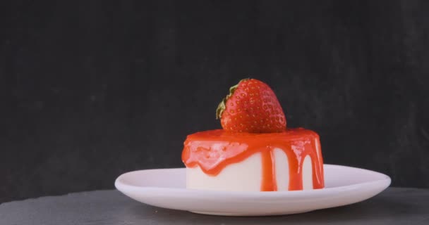 Sommerfrischkäsekuchen mit frischen Erdbeeren. Appetitliches Dessert auf Untertasse auf schwarzem Hintergrund.  - Filmmaterial, Video