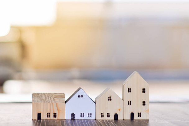 Modell eines kleinen Hauses auf einem Holzboden, Eigenheim und Immobilienkauf Ideen, Sonnenlicht und Kopierraum - Foto, Bild