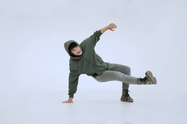 Lächelnder junger asiatischer Profitänzer ist Breakdance auf weißem Hintergrund im Studio. Bildung und Sport für Hobbys. - Foto, Bild
