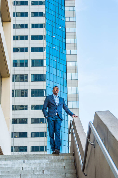 Un jeune homme d'affaires noir séduisant se tient devant un bâtiment d'affaires, confiant dans l'avenir - Photo, image