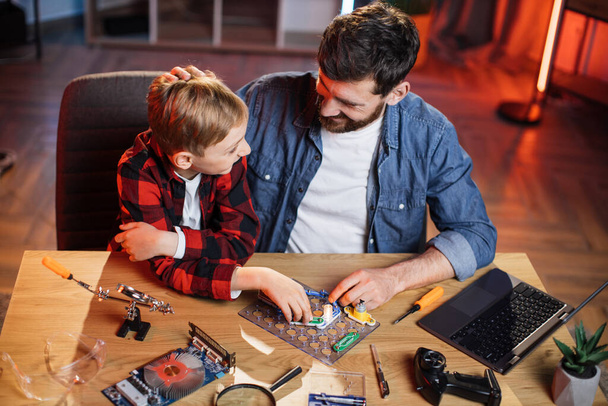 Dad with son doing electric circuit experiment at home - Foto, imagen