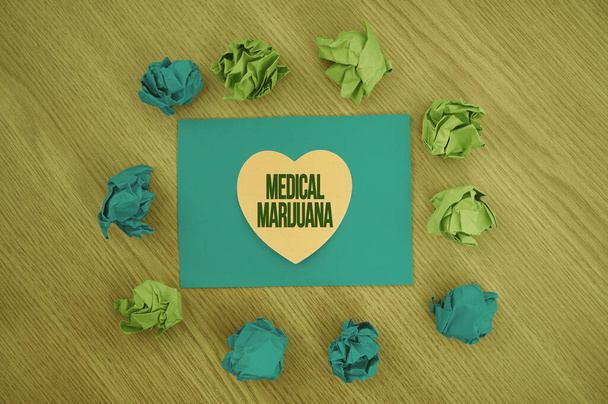 Writing displaying text Medical Marijuana. Conceptual photo recommended by examining as treatment of a medical condition Colorful Crumpled Papers Circular Pattern Surrounding Heart Shaped Card. - Foto, Imagen