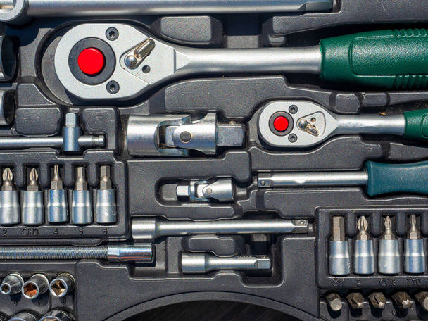 Een close-up van een set gereedschappen voor het repareren van een auto en andere dingen. sleutels, bits, aanhechtingen. Bovenaanzicht, vlak lay - Foto, afbeelding