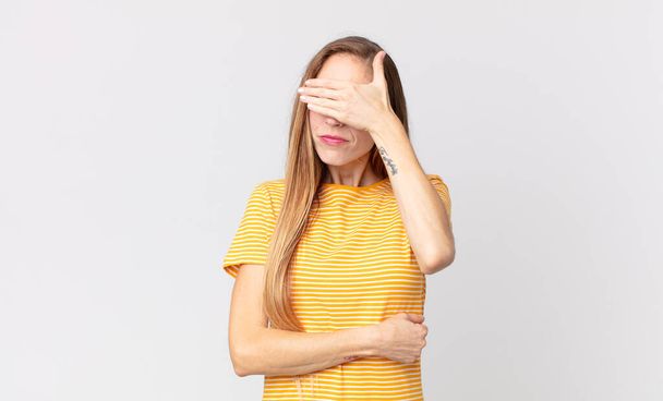 pretty thin woman looking stressed, ashamed or upset, with a headache, covering face with hand - Foto, Bild