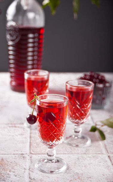 glasses of cherry brandy liqueur with ripe berries - Zdjęcie, obraz
