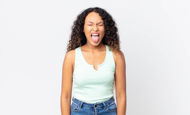 pretty hispanic woman with cheerful, carefree, rebellious attitude, joking and sticking tongue out, having fun - Φωτογραφία, εικόνα