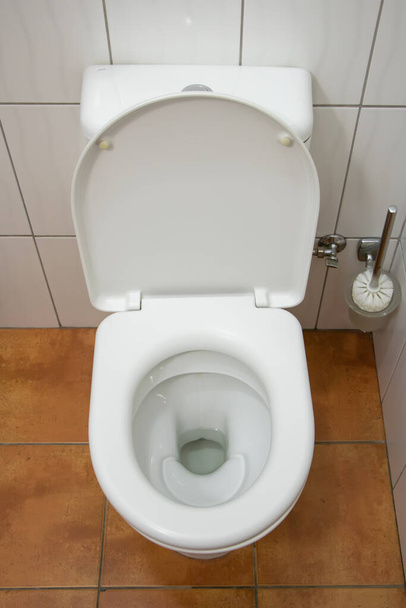 Νέα κεραμική λεκάνη τουαλέτας σε εσωτερικούς χώρους, κορυφαία άποψη. - Φωτογραφία, εικόνα