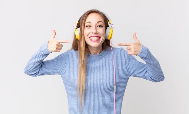 Pretty woman listening music in headphones - Fotografie, Obrázek