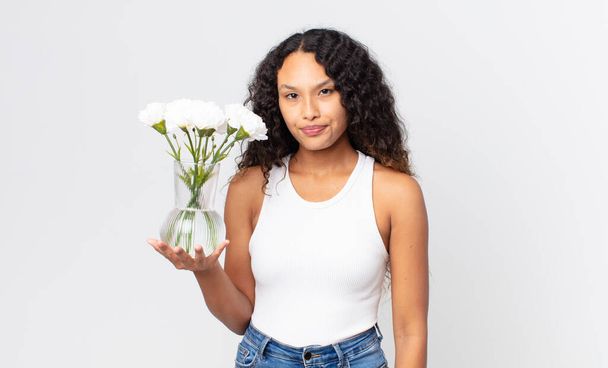 hispanic pretty woman feeling sad, upset or angry and looking to the side and holding a flowers jar - Photo, Image