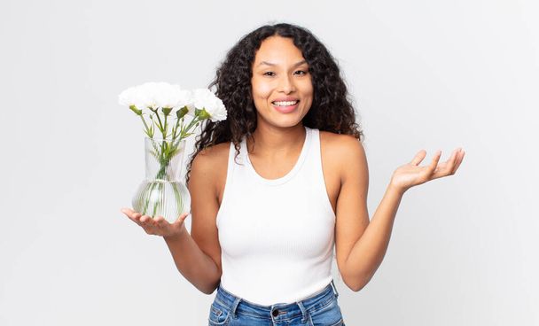 hispanic pretty woman feeling happy, surprised realizing a solution or idea and holding a flowers jar - Foto, immagini