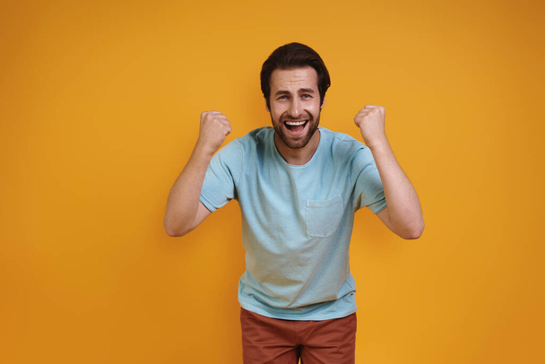 Happy young man in casual clothing looking at camera and gesturing - Photo, image