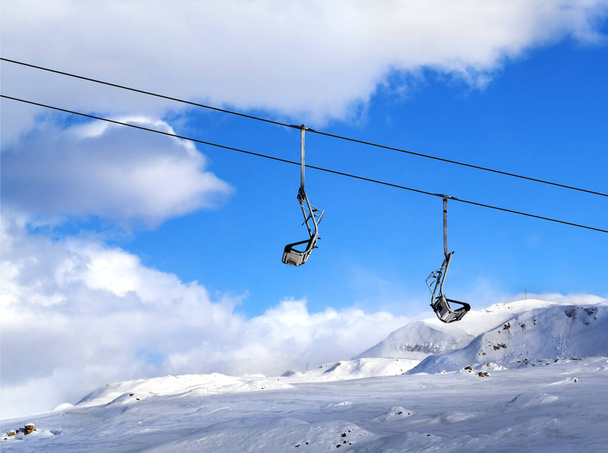 Two chair-lift on ski resort and blue sky with clouds at sun winter day - Foto, immagini