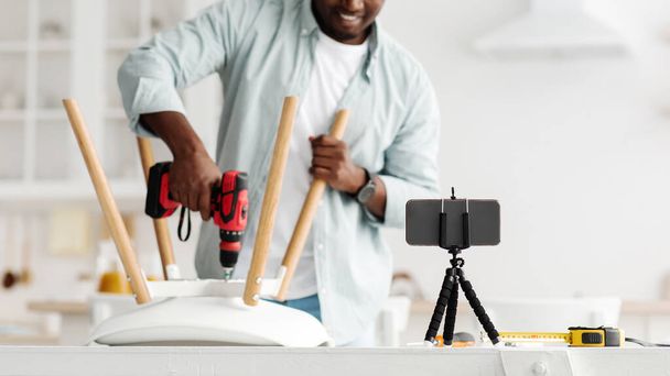 Handyman blogger schieten video-instructies voor het monteren van meubels thuis met eigen handen, met behulp van elektrische boor, gewas - Foto, afbeelding