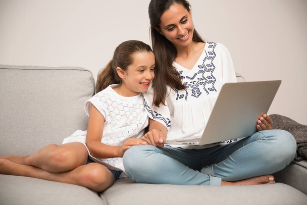 Mom teaching Daughter working with a a laptop at home9 - Фото, изображение