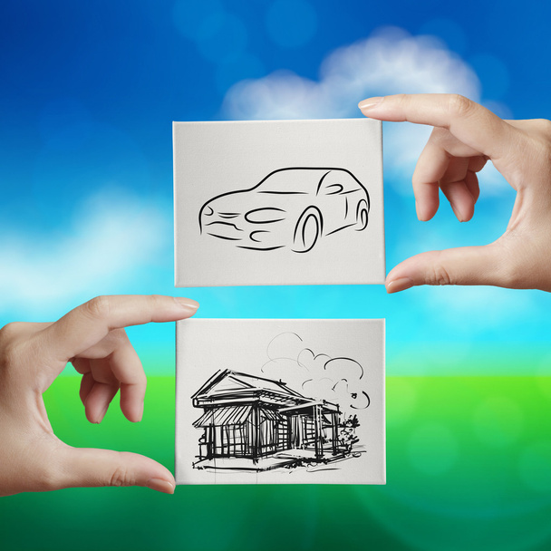 hand holding hand drawn house and car on canvas board on nature  - Photo, Image