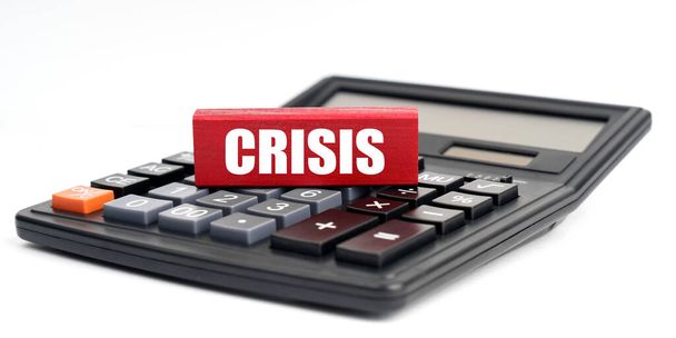 Business and finance concept. On a white background lies a calculator and Jenga with the inscription - CRISIS - Photo, image