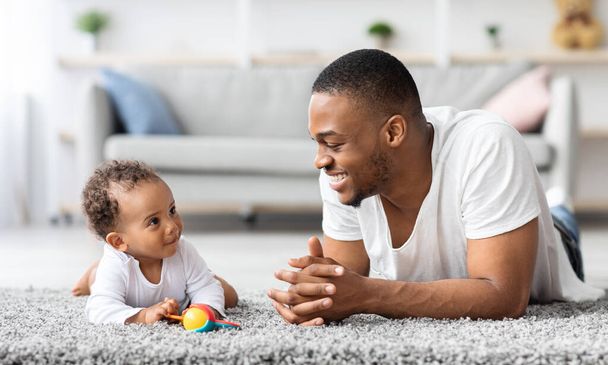 Padre Baby Connection. felice nero uomo legame con neonato bambino a casa - Foto, immagini
