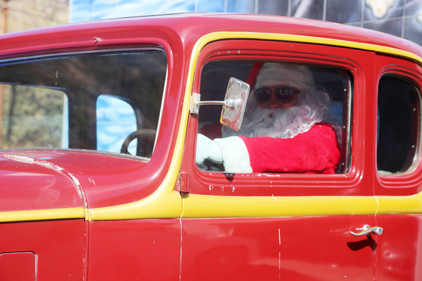 Santa Claus. Coche. Navidad. Regalo de Navidad. Santa Claus entrega un coche Red Hot Rod Race Car para Navidad. Papá Noel se prepara para Navidad. Papá Noel de vacaciones. Entregando regalos de Navidad. Papá Noel conduciendo un coche Hot Rod. Ho Ho Ho. - Foto, Imagen