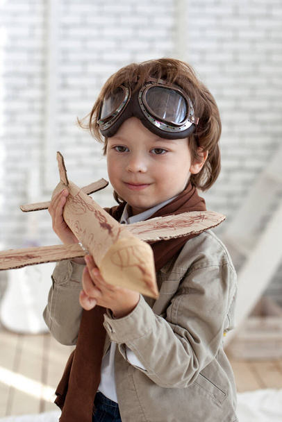 happy play boy with airplane in hand indoors - Foto, Imagem