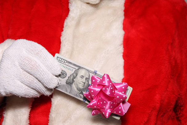 Χριστούγεννα. Άγιε Βασίλη. Φωτοθάλαμος. Η Σάντα Πόζες σε ένα φωτογραφείο. Ο Άγιος Βασίλης είναι αστείος. Διασκεδαστικές φωτογραφίες Σάντα. Άγιος Βασίλης κατέχει τα χρήματα ως χριστουγεννιάτικο δώρο σας. Μετρητά για τα Χριστούγεννα. Ο Άγιος Βασίλης κρατάει λεφτά. Δώρο από τον Άγιο Βασίλη. Ο Άγιος Βασίλης έχει λεφτά..  - Φωτογραφία, εικόνα