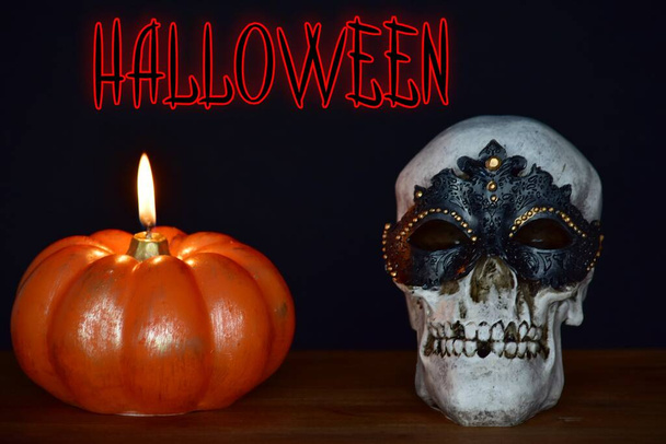 halloween lettering, pumpkin candle and masked skull on black background  - Fotoğraf, Görsel