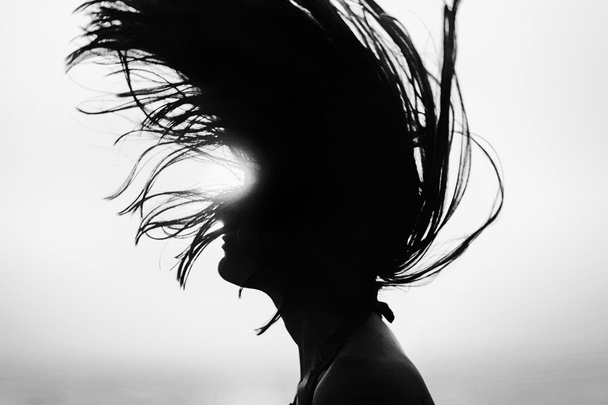 Silhouette de femme jetant les cheveux au coucher du soleil noir et blanc
 - Photo, image