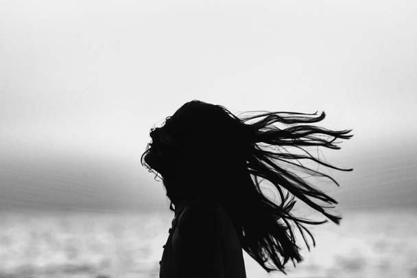 αφηρημένη γυναίκα πετώντας τα μαλλιά στο ηλιοβασίλεμα μαύρο και άσπρο - Φωτογραφία, εικόνα
