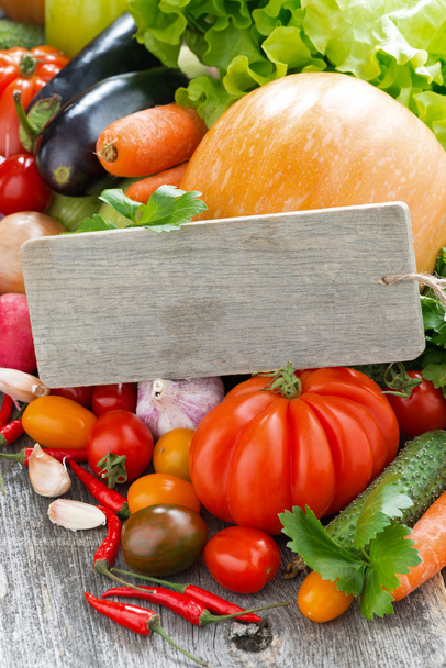 Assorted fresh seasonal vegetables and a wooden nameplate - Foto, afbeelding