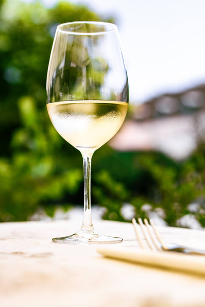 Fehér bor luxus étterem nyári kerti teraszon, borkóstoló tapasztalat pincészetben a szőlőskertben, ínyenc túra és nyaralás utazás - Fotó, kép
