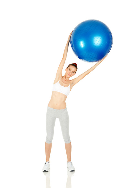 Fitness girl holding pilates ball - Foto, afbeelding