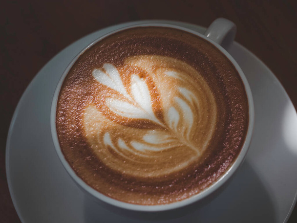 Tazza di caffè Latte art. Chiudi la texture della schiuma di latte in cappuccino di tazza di caffè caldo bianco con bella luce e ombra, vista dall'alto. - Foto, immagini