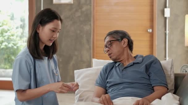 Medico di sesso femminile che controlla la salute del paziente asiatico di sesso maschile anziano a casa come servizio medico per visitare persone anziane malate dopo il pensionamento, assistenza medica, badante residenziale da professionista. - Filmati, video