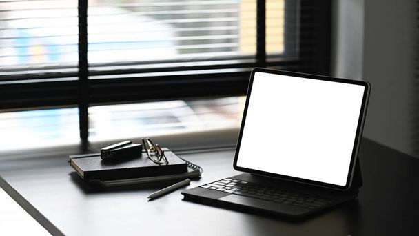 黒い木製のテーブルの上に空白の画面のタブレットコンピュータ、ノートブック、ペン、ガラス。商品表示モンタージュのブランク画面. - 写真・画像