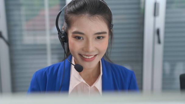 Bizneswoman w słuchawkach pracuje aktywnie w biurze - Zdjęcie, obraz