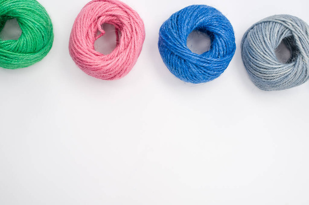 A closeup shot of soft colorful textile balls of wool on a white background with a copy space - Fotó, kép