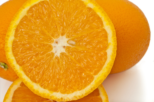 Close up capturing a selection of whole and halved fresh oranges over white. - Photo, Image