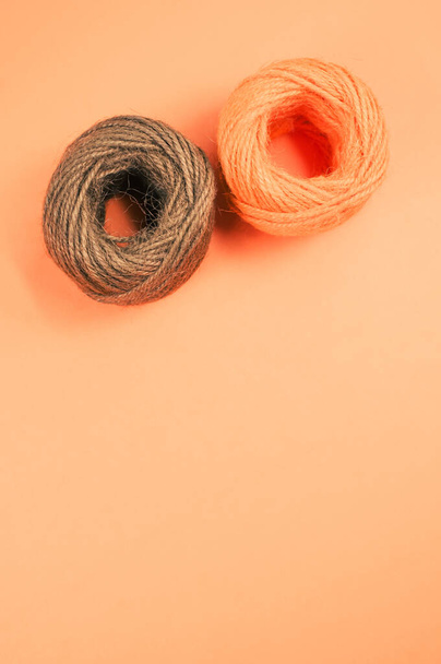 A closeup shot of soft colorful textile balls of wool on orange background with a copy space - Foto, imagen