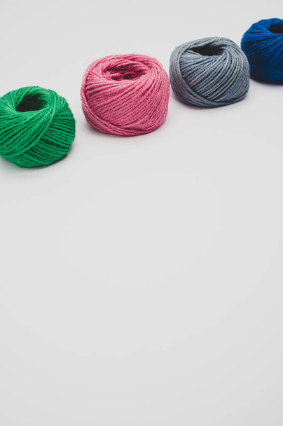 A closeup shot of soft colorful textile balls of wool on a white background with a copy space - Foto, Bild