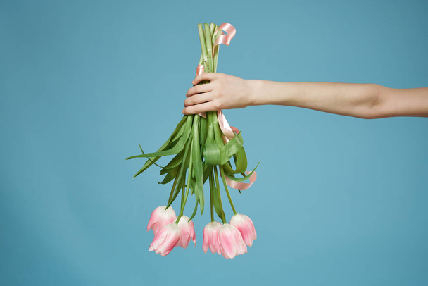 ramo de flores rosadas en la mano sobre fondo azul. Foto de alta calidad - Foto, imagen