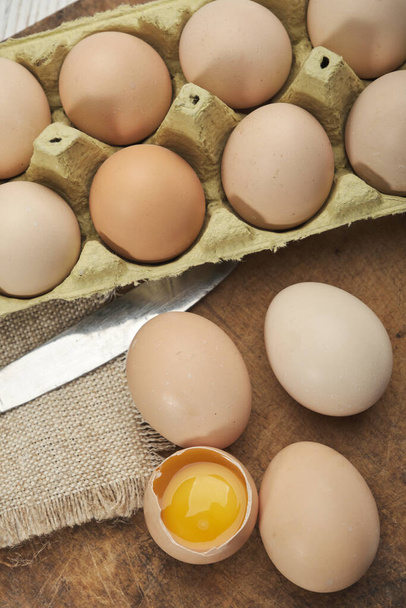 Großaufnahme roher Hühnereier in Eierschachtel auf hölzernem Hintergrund. Rohe Hühnereier in Eierkartons Biolebensmittel für eine gute Gesundheit mit hohem Eiweißgehalt . - Foto, Bild