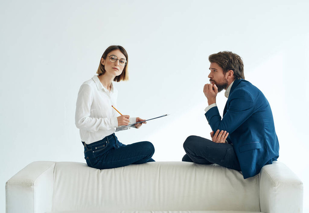 man and woman communication white sofa emotions team documents - Фото, зображення