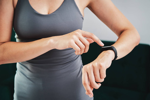 Woman use fitness tracker and doing sport exercise at home - Fotoğraf, Görsel