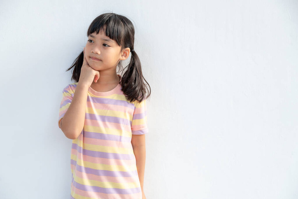 Nachdenkliche kleine Mädchen Kind berühren Kinn mit dem Finger denken oder erwägen, nachdenklich schöne Tochter Entscheidungsfindung eingebildete Idee posiert isoliert auf weißem Hintergrund - Foto, Bild