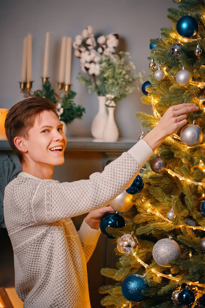 Gülümseyen adam Noel ağacını süslüyor.. - Fotoğraf, Görsel