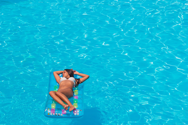 A girl is relaxing in a swimming pool - Φωτογραφία, εικόνα