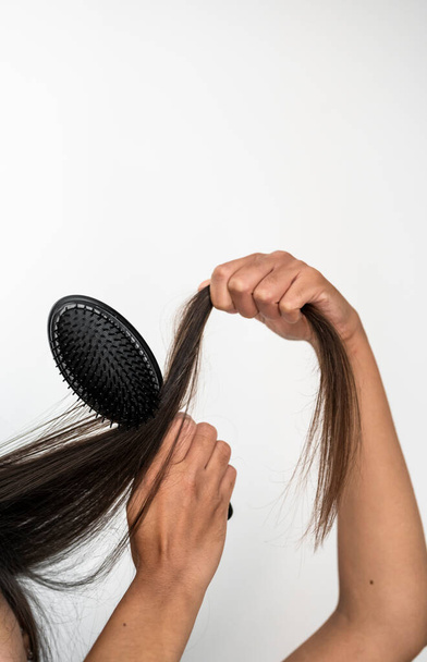 Femme peignage à la main en utilisant une brosse à cheveux - Photo, image