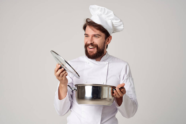 chef professionnel avec un pot dans les mains sur la cuisine  - Photo, image