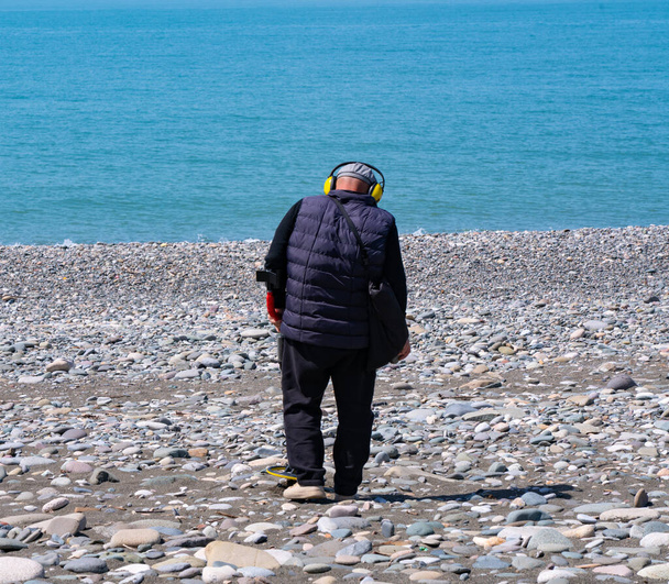 Batumi, Georgia - April 28, 2021: Man with a metal detector on the beach - Photo, Image