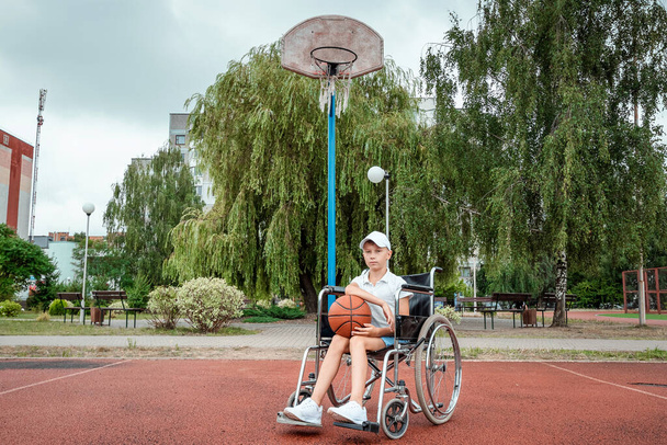 Concept of disabled child, support, rehabilitation, disabled person, paralyzed, happy disabled child. Disabled boy at school on the sports ground - Zdjęcie, obraz
