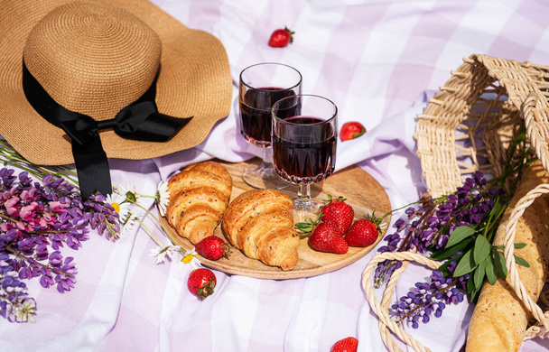 Escena romántica de picnic en el día de verano. Picnic al aire libre con vino y una fruta al aire libre en el fondo de hierba verde. - Foto, Imagen